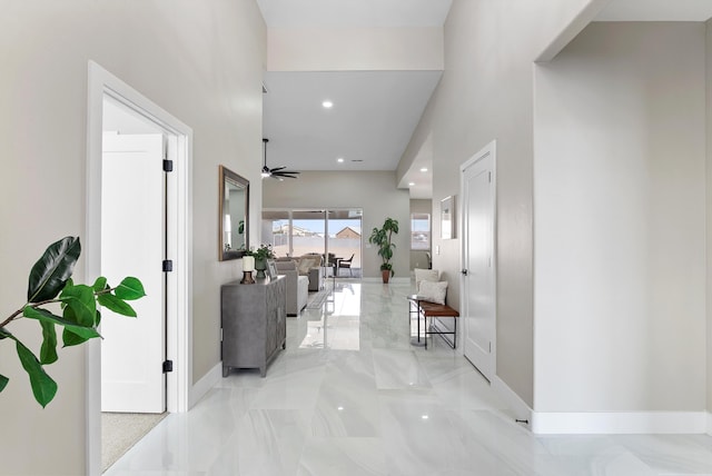 hall featuring marble finish floor, recessed lighting, and baseboards