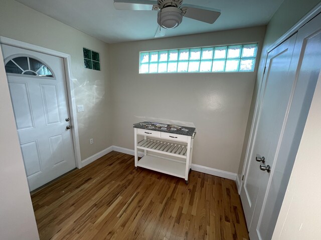 entryway featuring wood finished floors, a ceiling fan, and baseboards