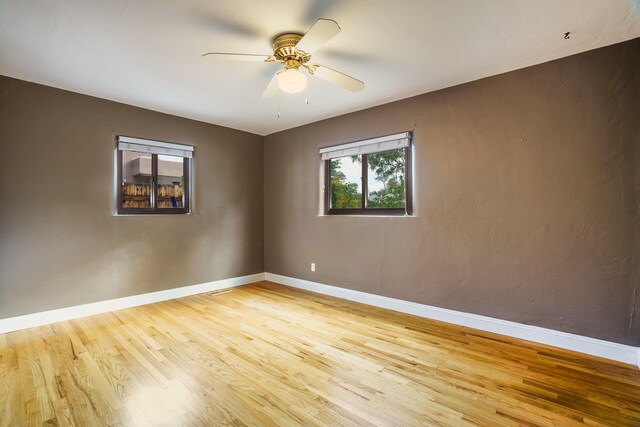 unfurnished room featuring ceiling fan, baseboards, and wood finished floors