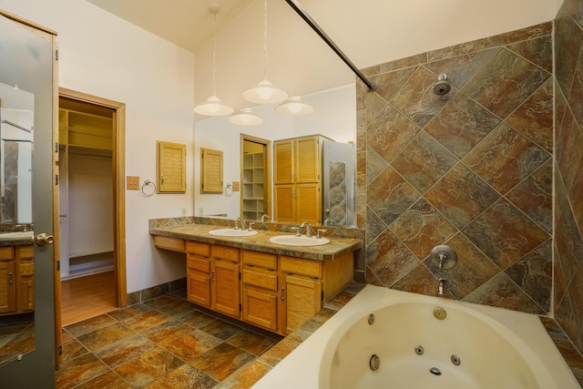 full bathroom featuring double vanity, a spacious closet, and a sink