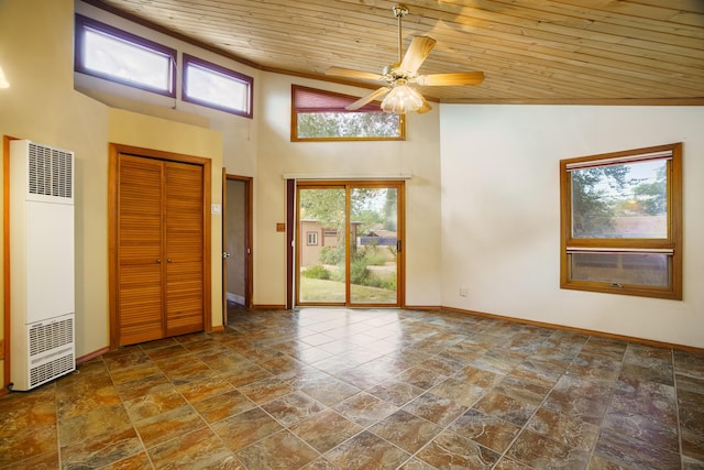 unfurnished room featuring high vaulted ceiling, a heating unit, wood ceiling, and baseboards