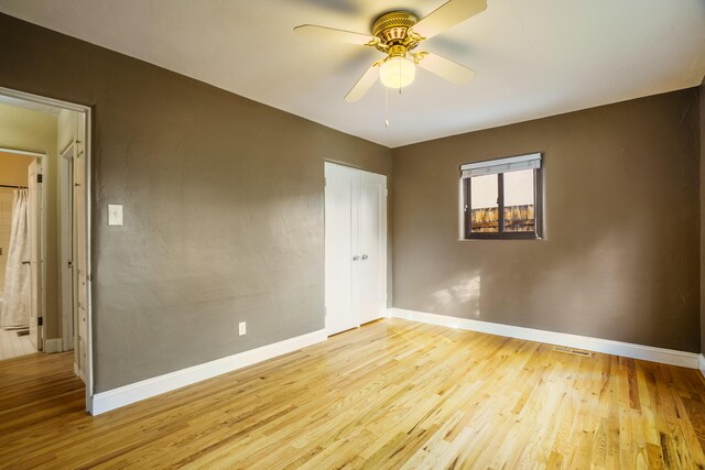 unfurnished room with light wood-style floors, ceiling fan, and baseboards