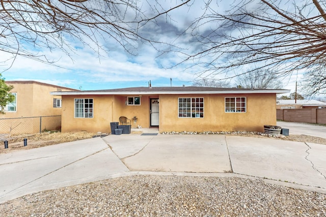 rear view of property with fence and stucco siding