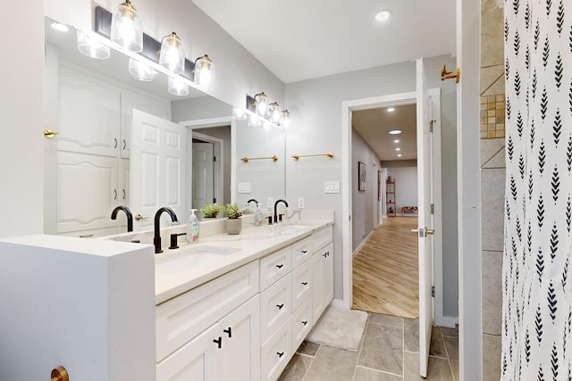 full bathroom featuring a shower, recessed lighting, a sink, and double vanity