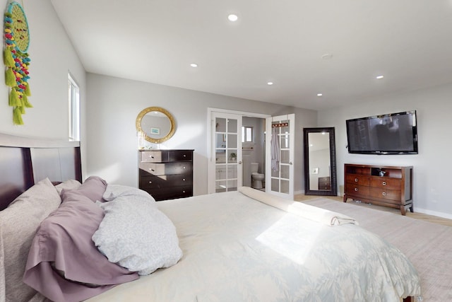 bedroom featuring baseboards, wood finished floors, ensuite bathroom, french doors, and recessed lighting