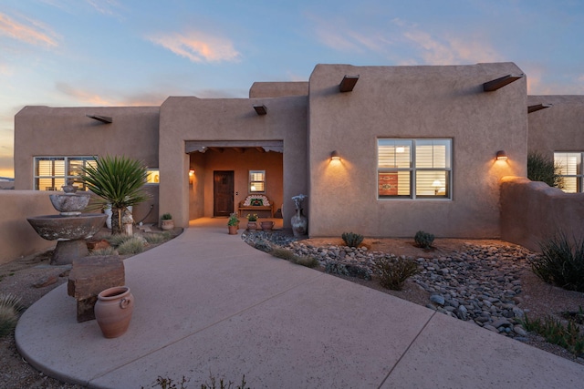 pueblo-style house featuring stucco siding