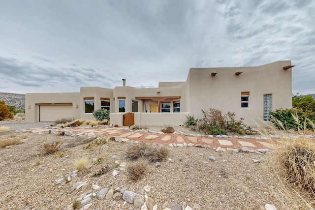 southwest-style home featuring a garage and stucco siding