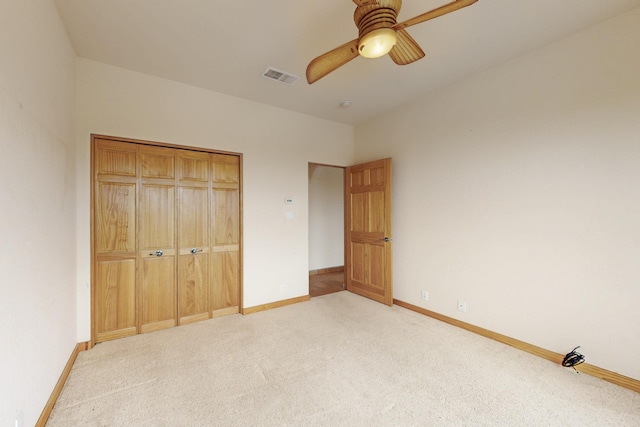 unfurnished bedroom with baseboards, visible vents, a closet, and light colored carpet