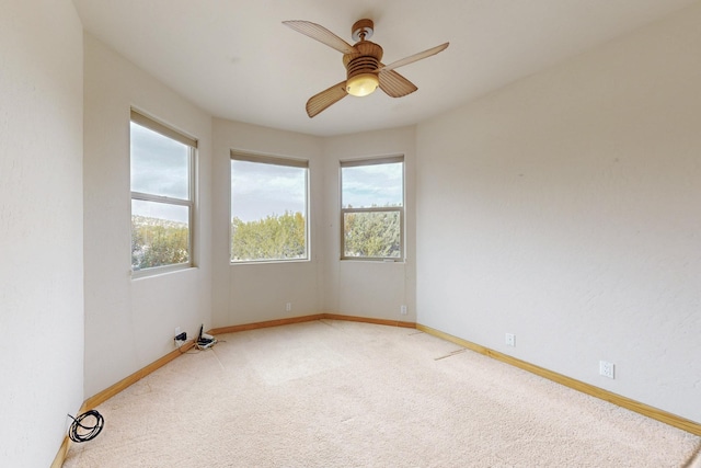 spare room with a ceiling fan, carpet, and baseboards