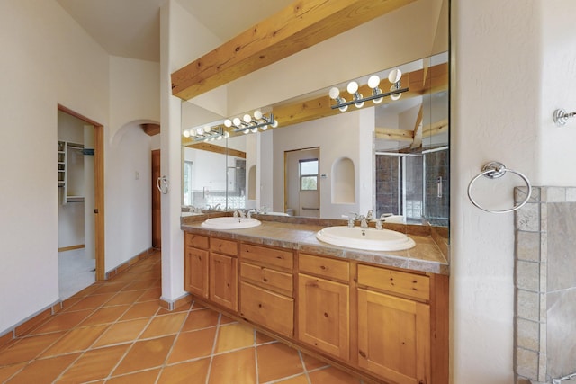 full bath with double vanity, a stall shower, a sink, and tile patterned floors