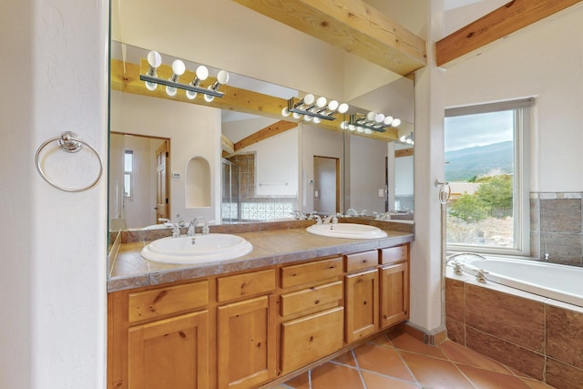 full bathroom with a garden tub, double vanity, tile patterned flooring, and a sink