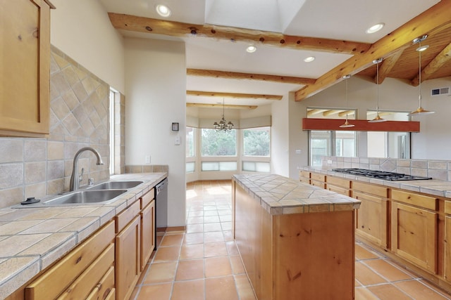 kitchen featuring tile countertops, dishwashing machine, a sink, and a center island