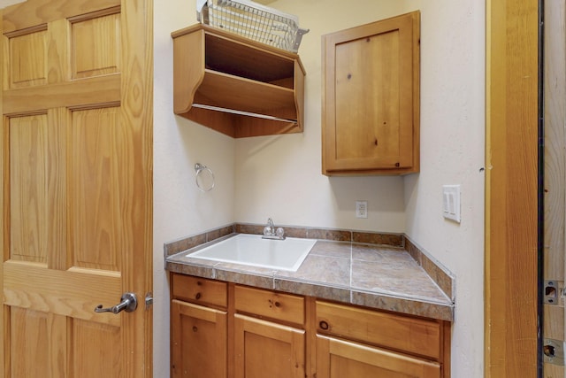 kitchen featuring open shelves and a sink