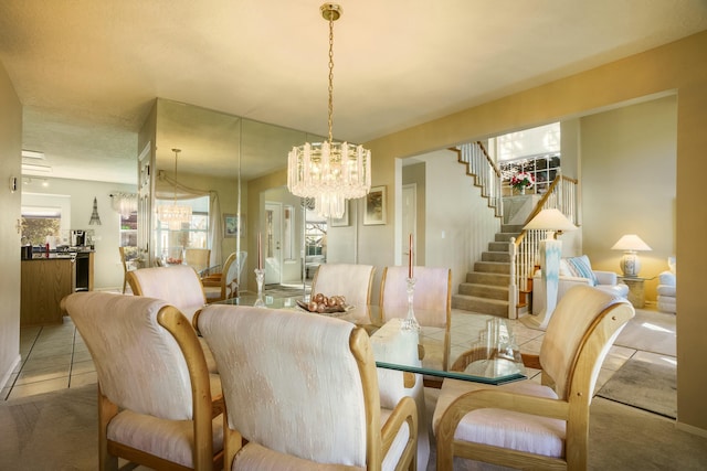 dining space with a chandelier, stairway, and light tile patterned floors