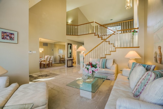 living room featuring a towering ceiling, stairs, visible vents, and carpet flooring