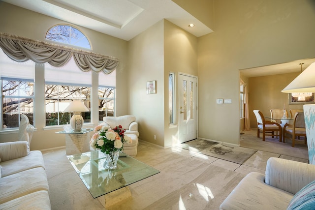 tiled living room with a high ceiling, carpet flooring, and baseboards