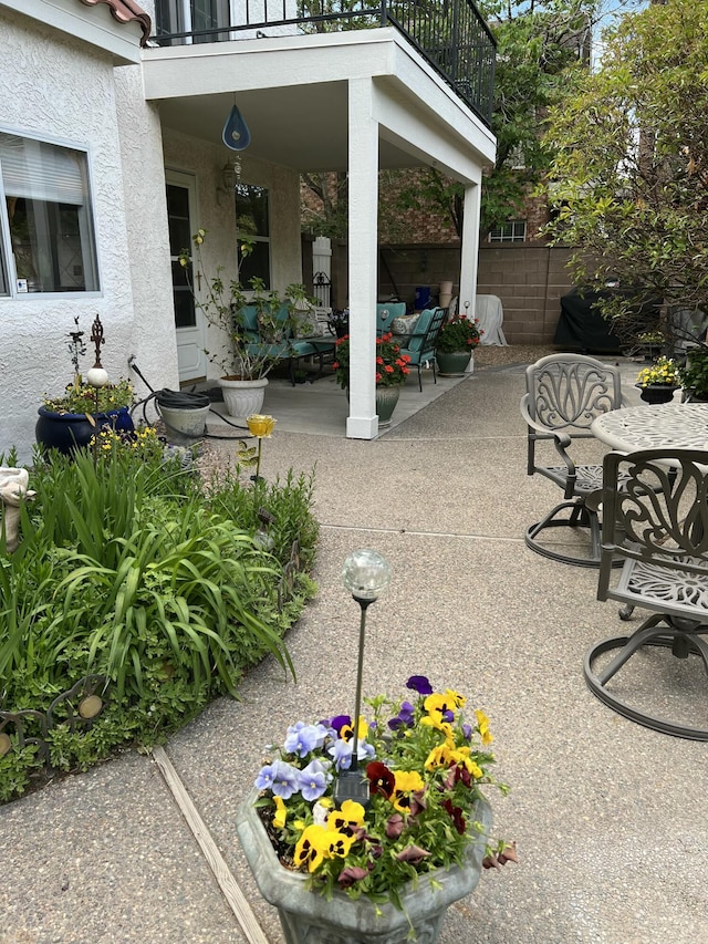 view of patio / terrace featuring fence and a balcony