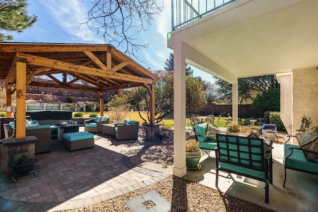 view of patio featuring fence, an outdoor living space, and a gazebo