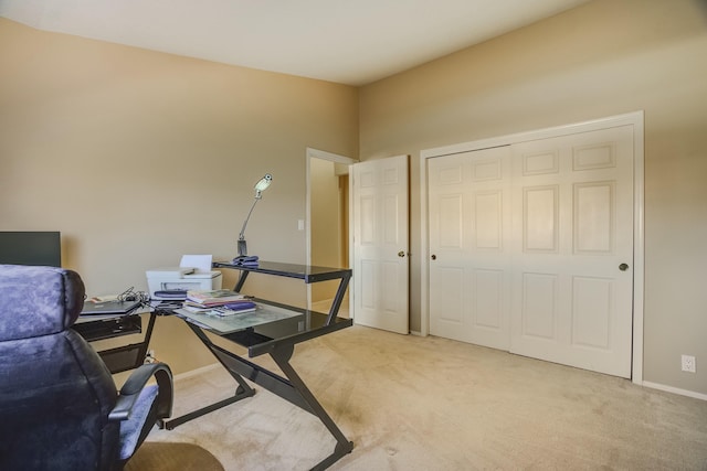 office area featuring baseboards and light colored carpet