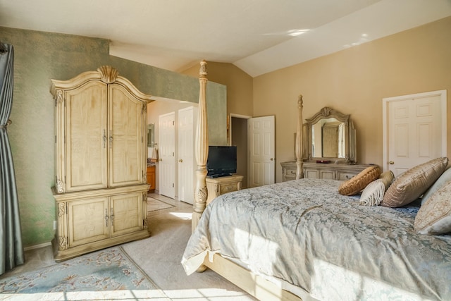 bedroom featuring connected bathroom, light carpet, and vaulted ceiling