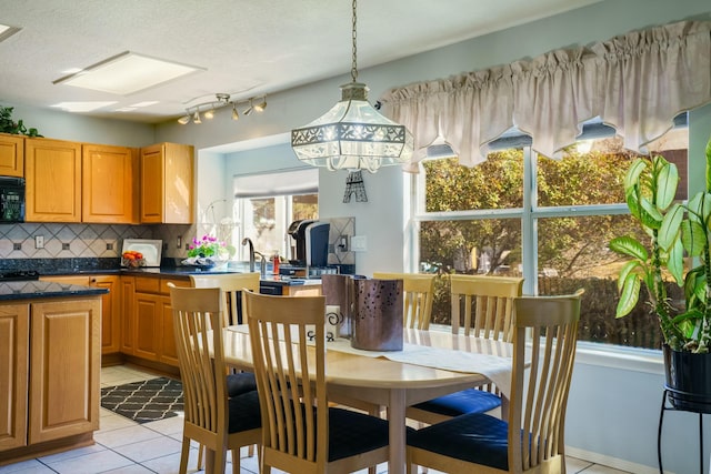 dining area with light tile patterned flooring and a textured ceiling