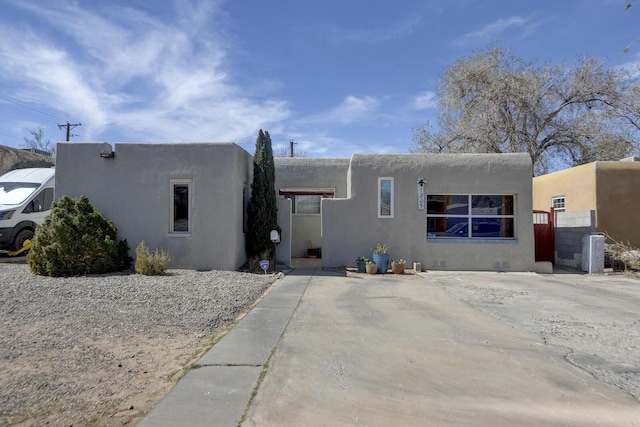 adobe home featuring crawl space, fence, and stucco siding