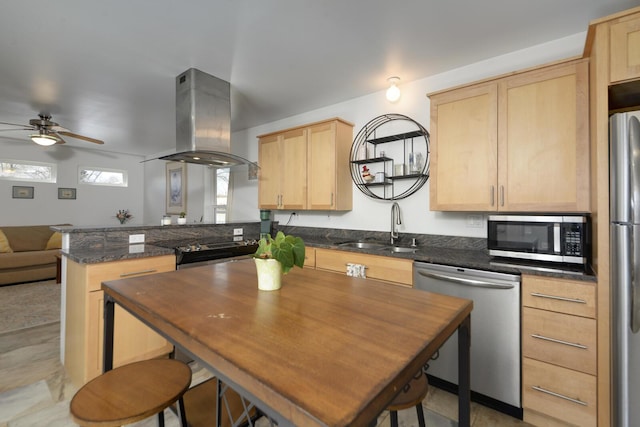 kitchen featuring stainless steel appliances, a peninsula, a sink, light brown cabinetry, and island exhaust hood