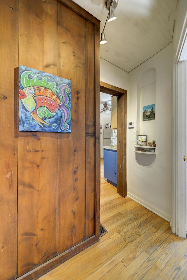 hallway featuring light wood-style floors and baseboards