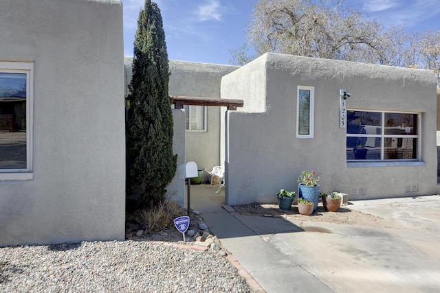 view of side of home featuring a patio, crawl space, and stucco siding