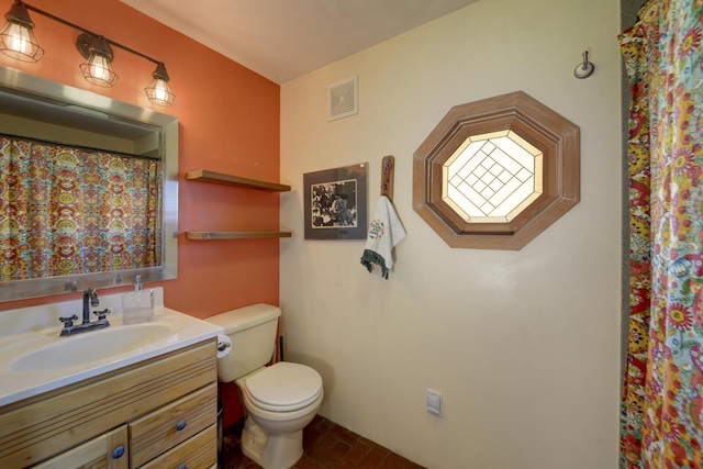 bathroom featuring toilet, visible vents, and vanity