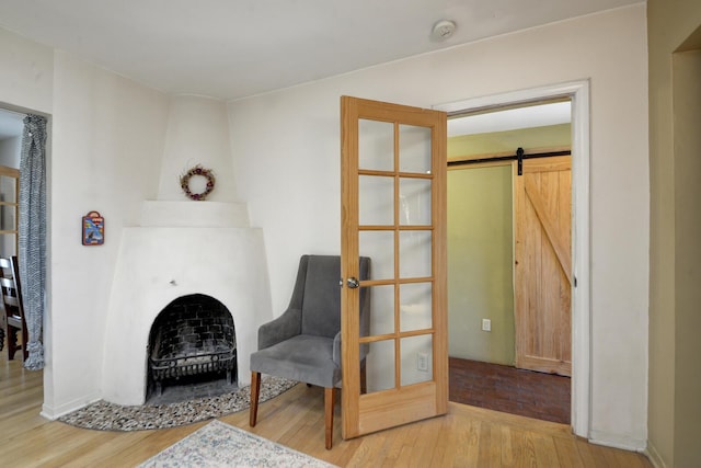 living area featuring a barn door and wood finished floors