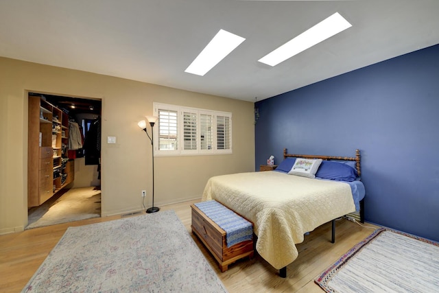 bedroom with lofted ceiling, baseboards, and wood finished floors