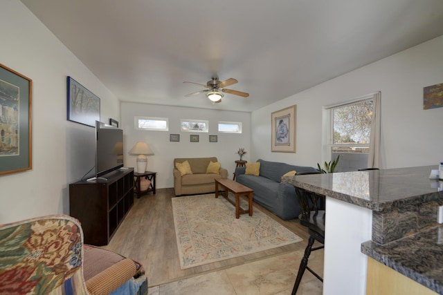 living room featuring light wood finished floors and a ceiling fan