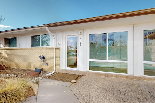 view of home's exterior with board and batten siding and brick siding