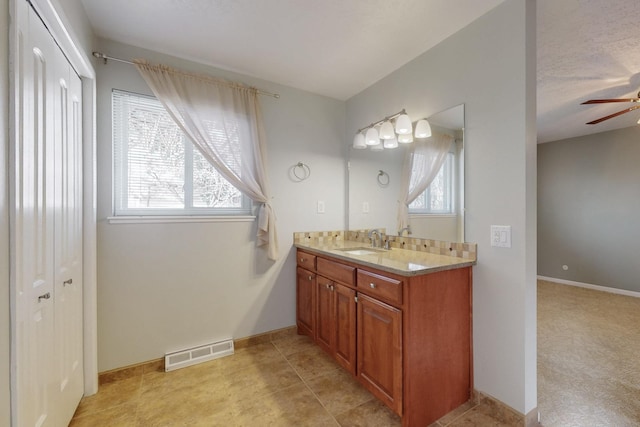 bathroom featuring vanity, baseboards, visible vents, and ceiling fan