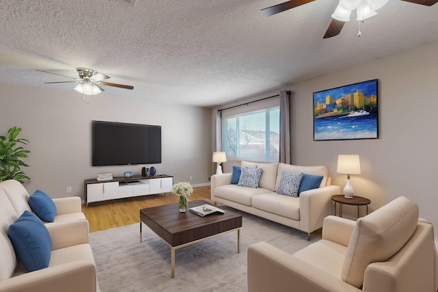 living room with baseboards, a textured ceiling, a ceiling fan, and wood finished floors