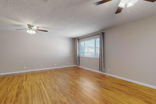 empty room featuring light wood-style flooring, baseboards, and a textured ceiling