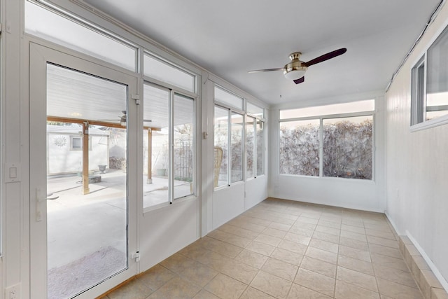 unfurnished sunroom featuring a healthy amount of sunlight and ceiling fan