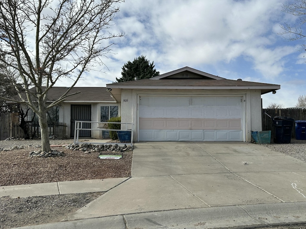 ranch-style house with stucco siding, concrete driveway, a garage, and fence