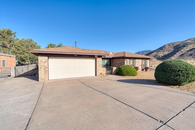 ranch-style house featuring concrete driveway, an attached garage, and brick siding