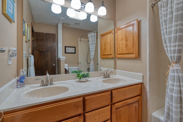 full bath with a textured ceiling, toilet, visible vents, and a sink