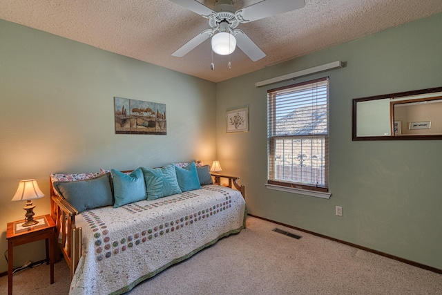 carpeted bedroom featuring visible vents, ceiling fan, a textured ceiling, and baseboards