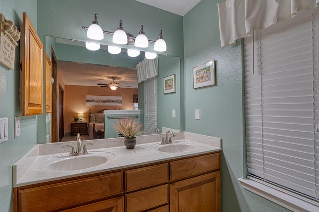 ensuite bathroom with double vanity, a textured ceiling, ensuite bath, and a sink