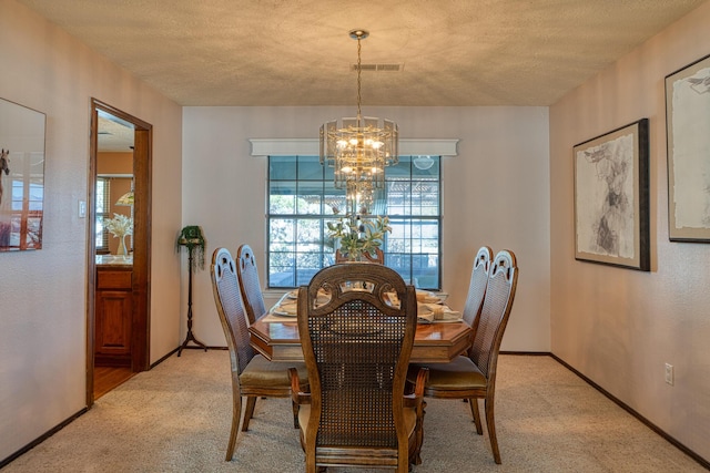 dining area featuring visible vents, baseboards, a chandelier, light colored carpet, and a textured ceiling