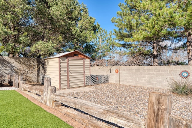 view of yard with an outbuilding, a shed, and a fenced backyard