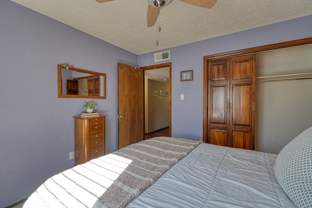 bedroom featuring visible vents, a textured ceiling, a closet, and ceiling fan