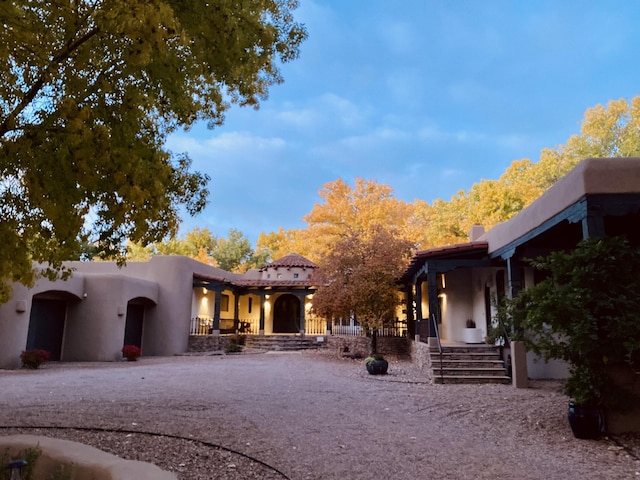 pueblo revival-style home featuring a porch
