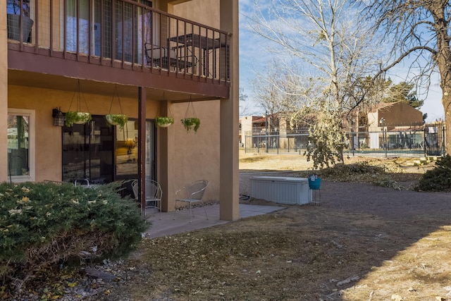 view of yard featuring a patio area, a balcony, and fence