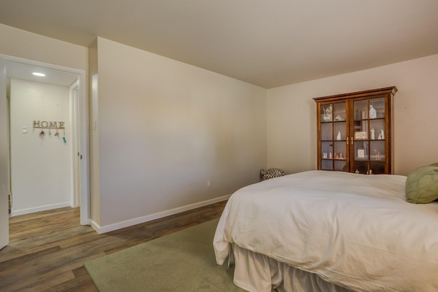 bedroom with baseboards and wood finished floors