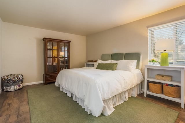 bedroom featuring wood finished floors and baseboards